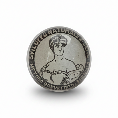 PostaFerma rotondo in vetro con ritaglio originale di una pubblicità del 1907 tratta da La Domenica del Corriere. Fermacarte decorativo, pezzo unico realizzato a mano con retro rifinito in velluto nero.
