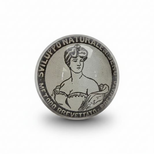 PostaFerma rotondo in vetro con ritaglio originale di una pubblicità del 1907 tratta da La Domenica del Corriere. Fermacarte decorativo, pezzo unico realizzato a mano con retro rifinito in velluto nero.
