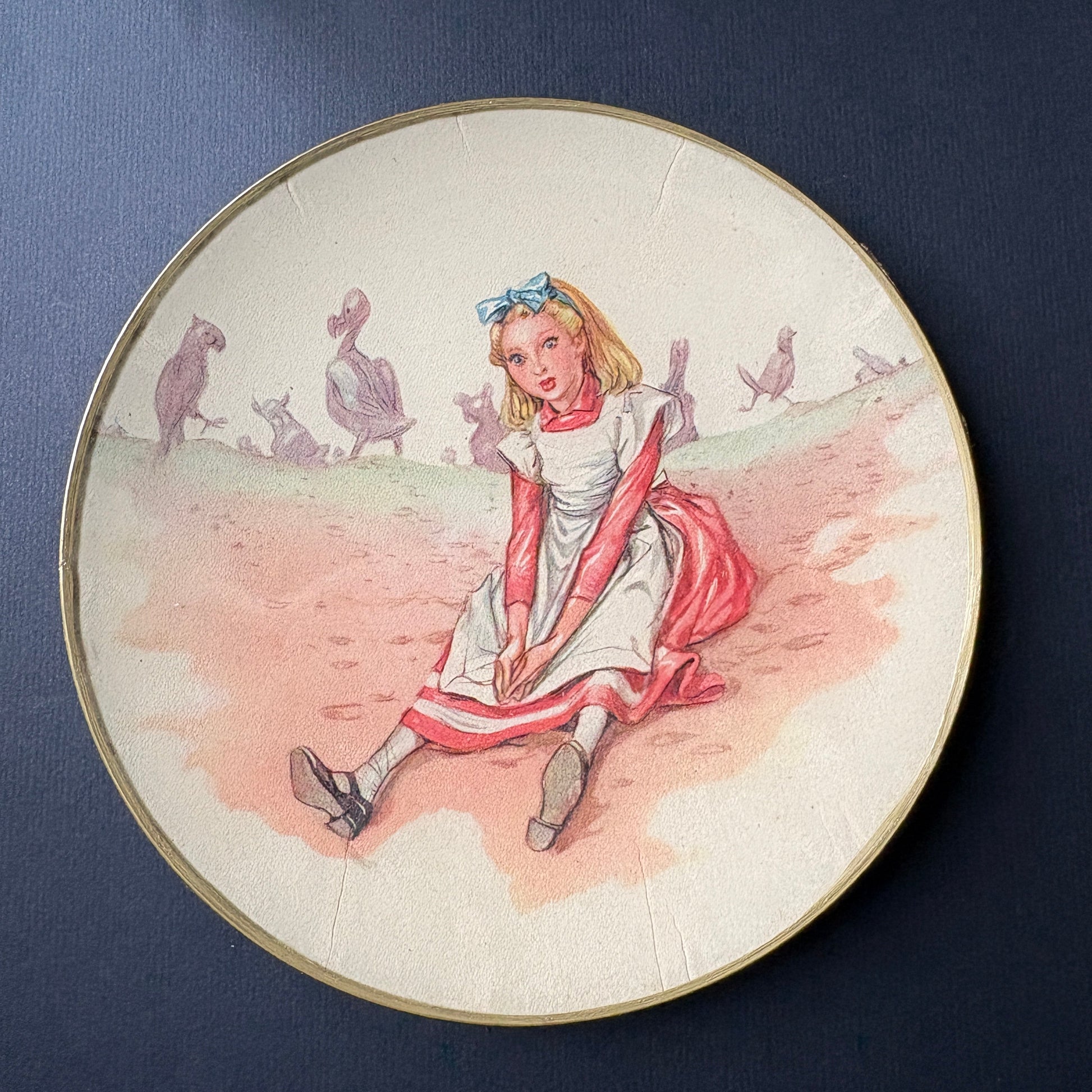 Shelfie artigianale tondo da 15 cm con ritaglio originale vintage di Alice nel Paese delle Meraviglie, edizione Fratelli Fabbri, realizzato a mano a Milano con fondo in velluto nero e bordo dorato, pezzo unico decorativo e svuotatasche narrativo